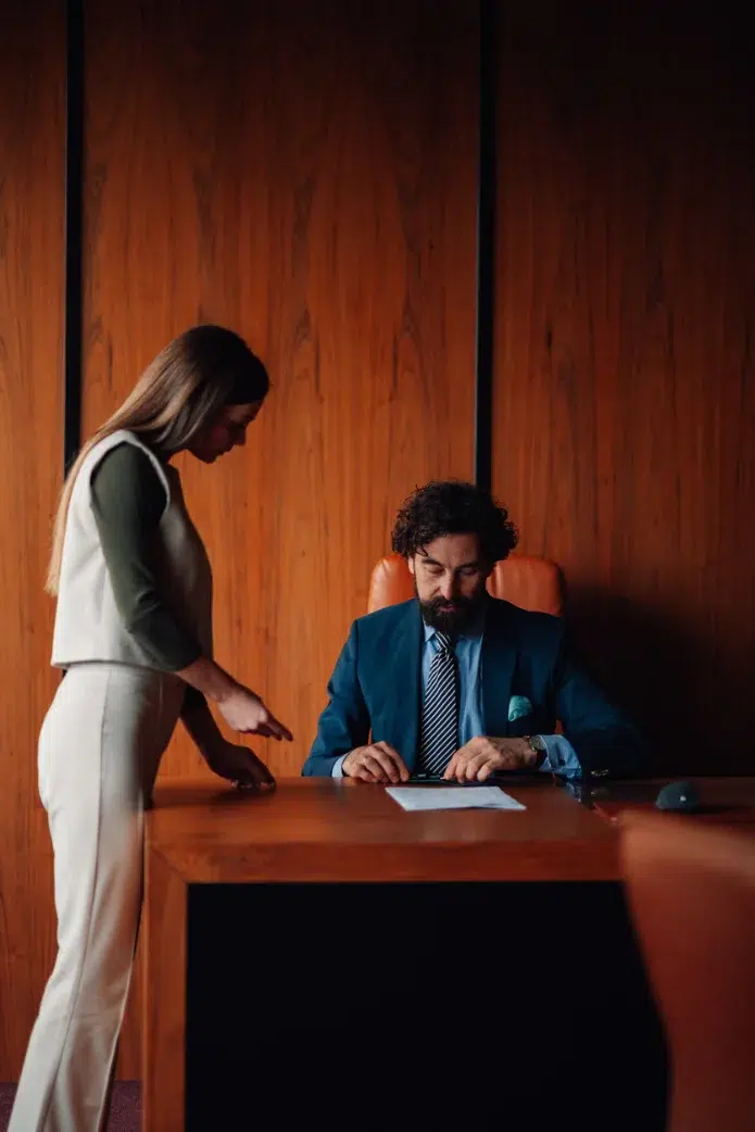 Two people reviewing a document in a wood-panelled office