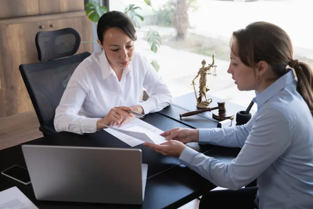Attorney reviewing documents across a desk with a client